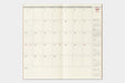 An open monthly planner spread showing September with cream-colored pages, gray headers, and red date highlights, photographed against a light gray background.