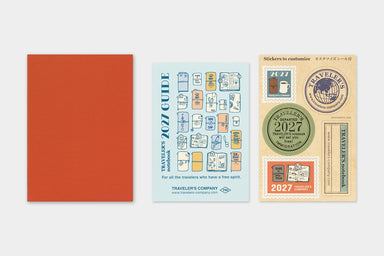 TRAVELER'S notebook Passport Size 2027 Monthly Diary showing front cover, guide, and sticker sheet