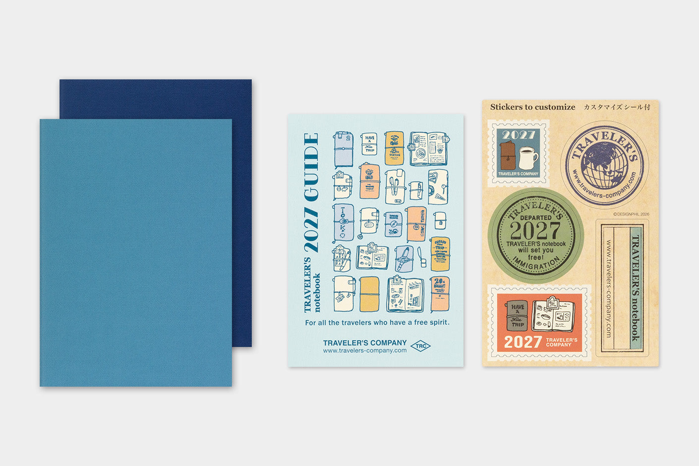 TRAVELER'S notebook Refill- Passport Size- 2027 Weekly Diary displayed on a light gray background, featuring two blue Diaries, a light blue card labeled 'Travelers' 2027 Guide', and one sticker sheet with travel-themed labels.