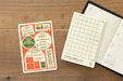 TRAVELER'S notebook 2027 Passport Plastic Sheet showing front of sheet and back of sheet sitting on an open TRAVELER'S notebook (not included)