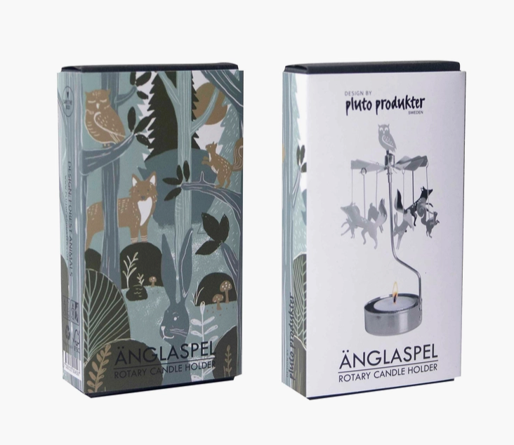 Two product boxes for the Anglaspel Rotary Candle Holder by Pluto Produkte, shown on a light gray background. One box features a woodland animal illustration in muted blue, beige, and brown tones, and the other is the reverse side- white with black and gray illustrations of the candle holder.