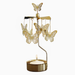 A gold-toned metal butterfly mobile candle holder with several hanging butterfly ornaments and a lit tealight candle in a round gold holder, shown against a plain white background.