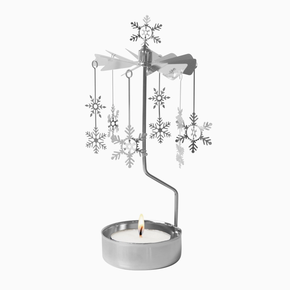 A silver metal winter-themed candle holder featuring a wind spinner with hanging snowflakes and a lit tealight candle in a round silver holder, set against a plain white background.