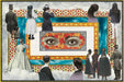 Interior page example from The Antiquarian Sticker Book: Mysterium- A surreal collage-style artwork showing multiple figures in vintage clothing floating among clouds around a central ornate frame, with a pair of eyes painted in red, orange, and yellow tones at the heart of the composition.