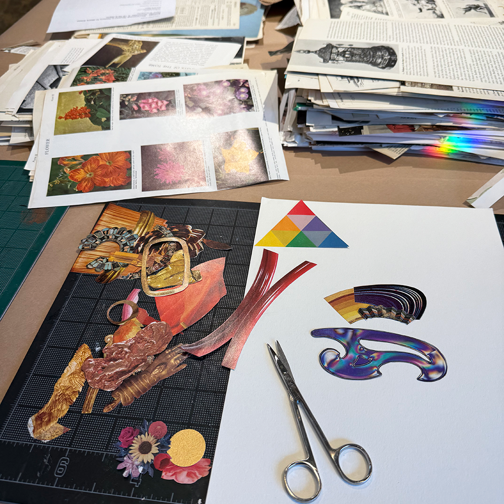 Art supplies including scissors, paper cutouts, and a cutting mat on a table.