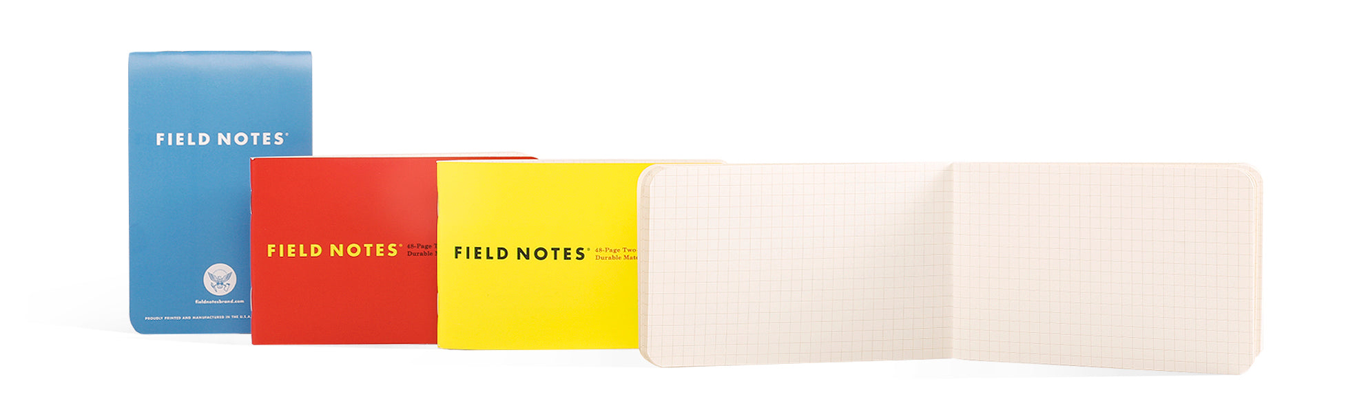 Three Field Notes notebooks in blue, red, and yellow with an open notebook on a white background.