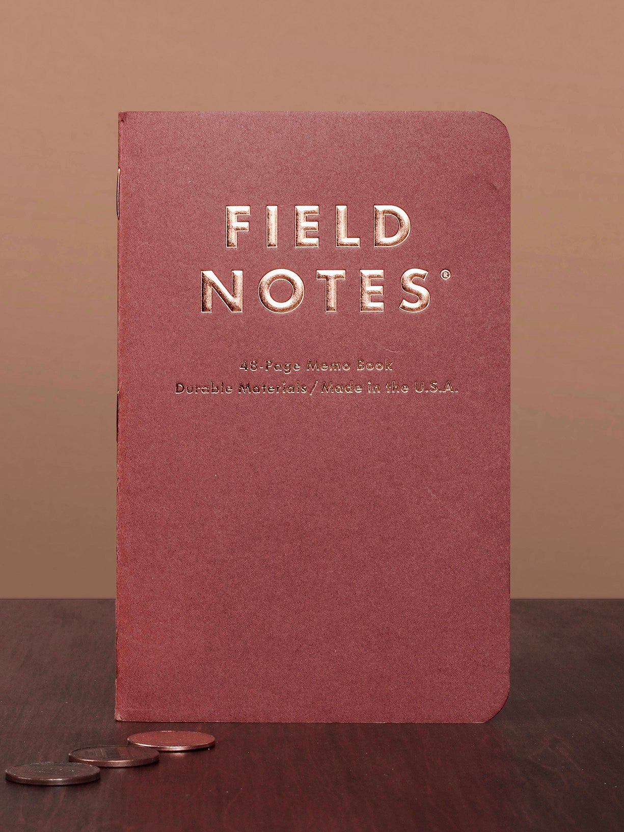 Red notebook with 'Field Notes' branding on a brown background