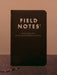 Black Field Notes notebook on a wooden surface with a brown background