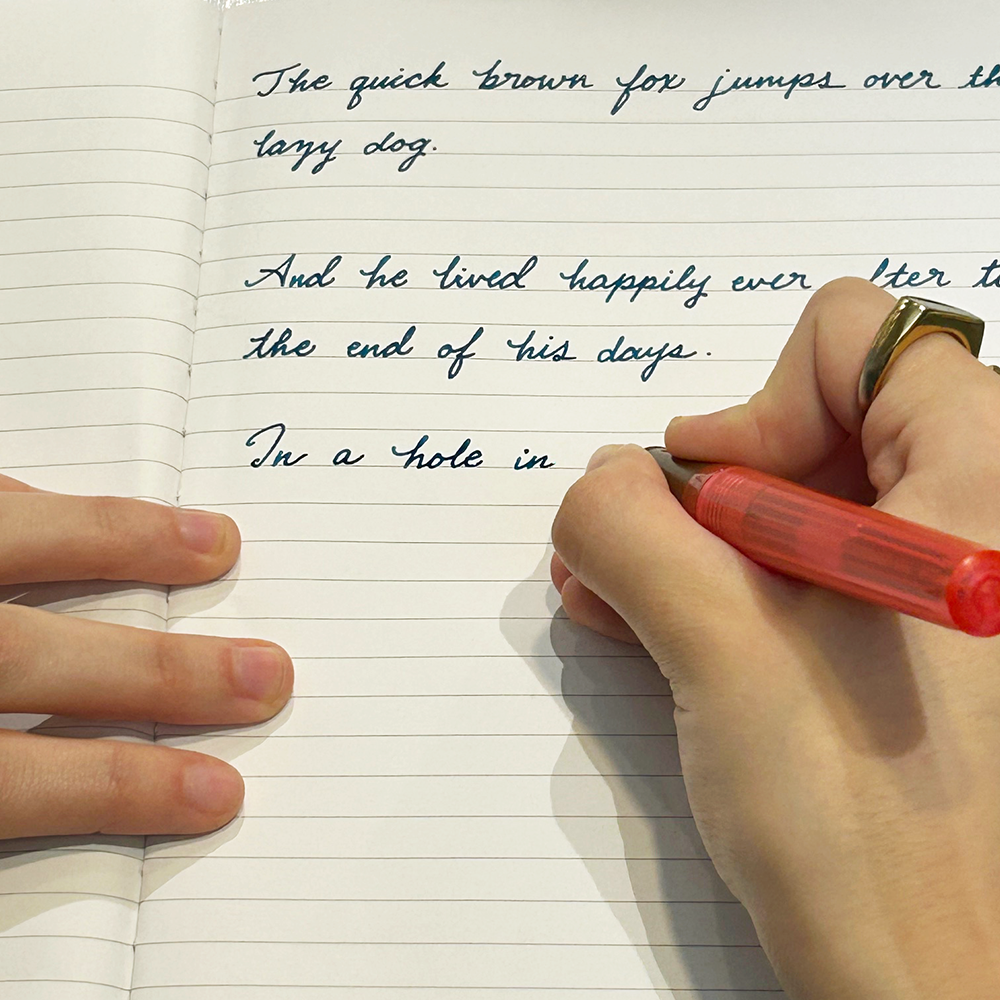 Handwriting practice with a red  fountain pen on lined paper