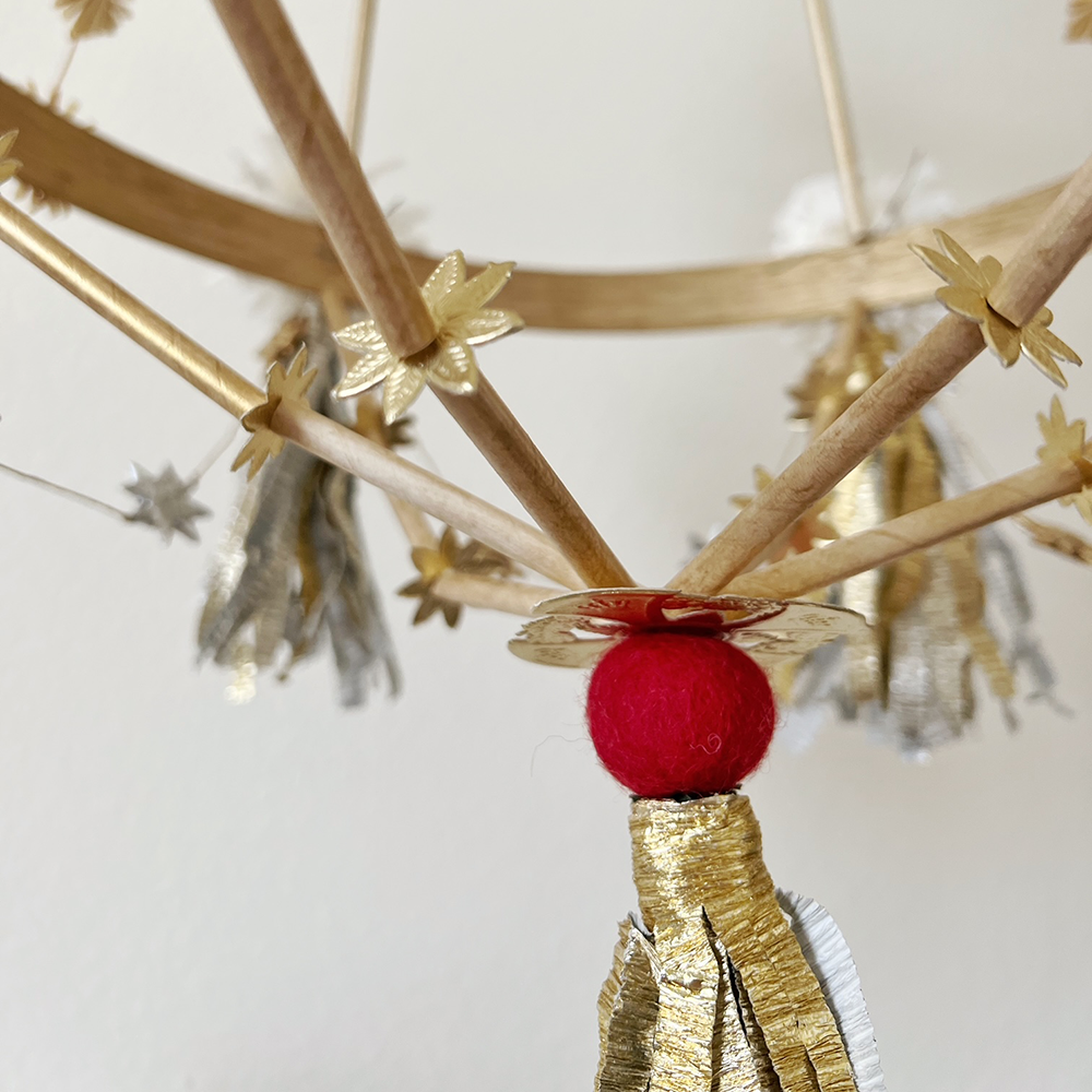 Red wool felt ball used as part of a pajak decoration- detail