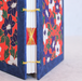 Decorative journal spine detail with floral patterns and yellow string binding on a light gray background