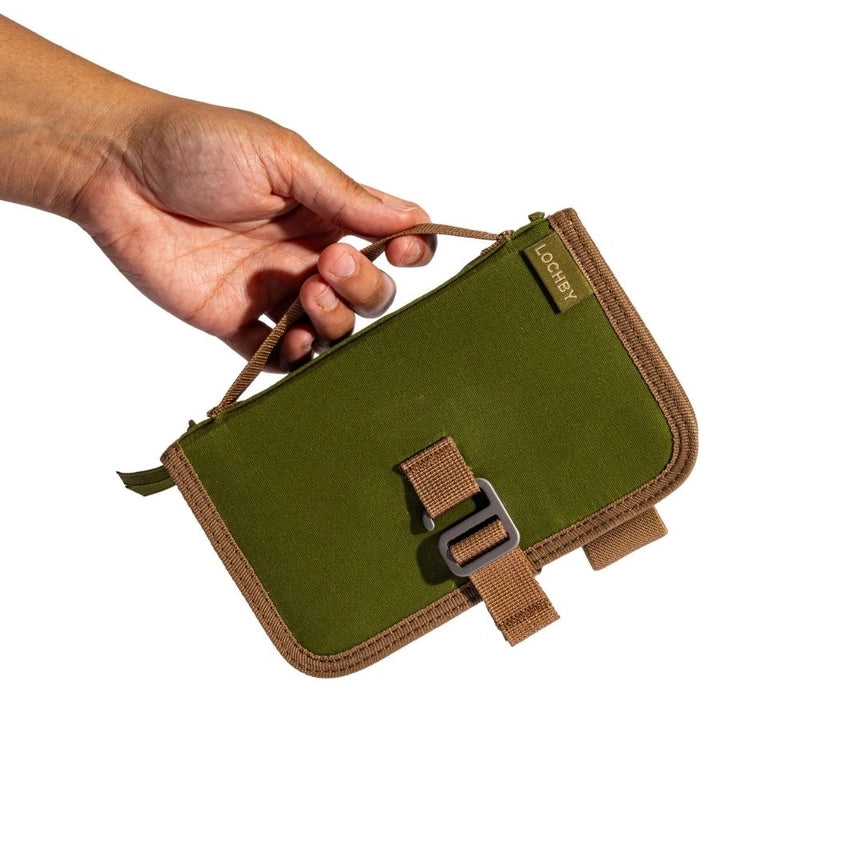 Lochby Mini Field Journal- olive with beige interior- olive cover with beige strap held by a hand on a white background