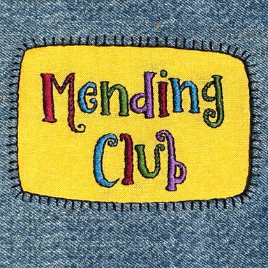 "Mending Club" stitched on a patch attached to blue jeans