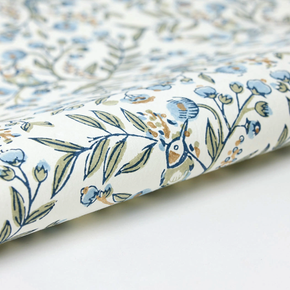 Floral and bird patterned paper with blue flowers and green leaves on a white background- detail