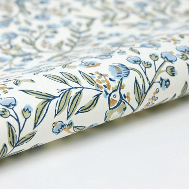 Floral and bird patterned paper with blue flowers and green leaves on a white background- detail