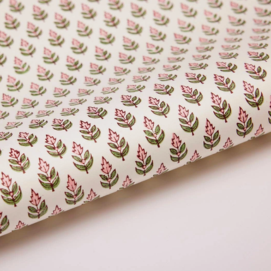 paper with repeating pink and green floral pattern on a white background