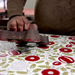 Artist block printing paper showing the stamping process- marigold red with green leaves