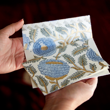 Hand Block Printed Single Card- Flowering Marigold- pale blue, green, and gold ink held in two hands showing card and envelope