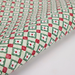 Patterned paper with red, green, and white design on a white background