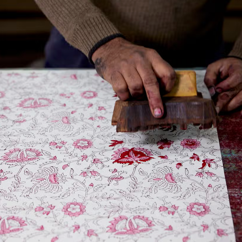 Block priting in progrss- printing flower details with woodblock in hands