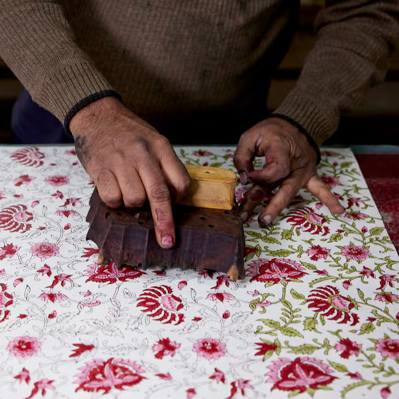 Block priting in progrss- printing green vines with woodblock in hands