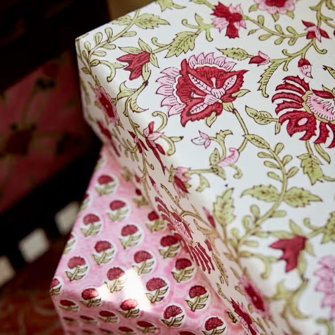 Red and pink flowers with green leaves on white background used as a gift wrap with a second box and different pattern