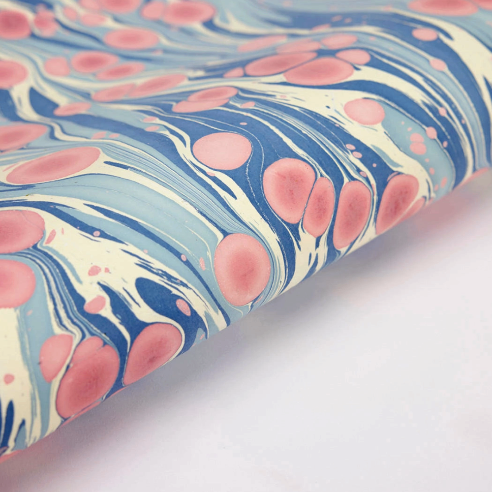 Marbled paper with pink and blue patterns on a white background