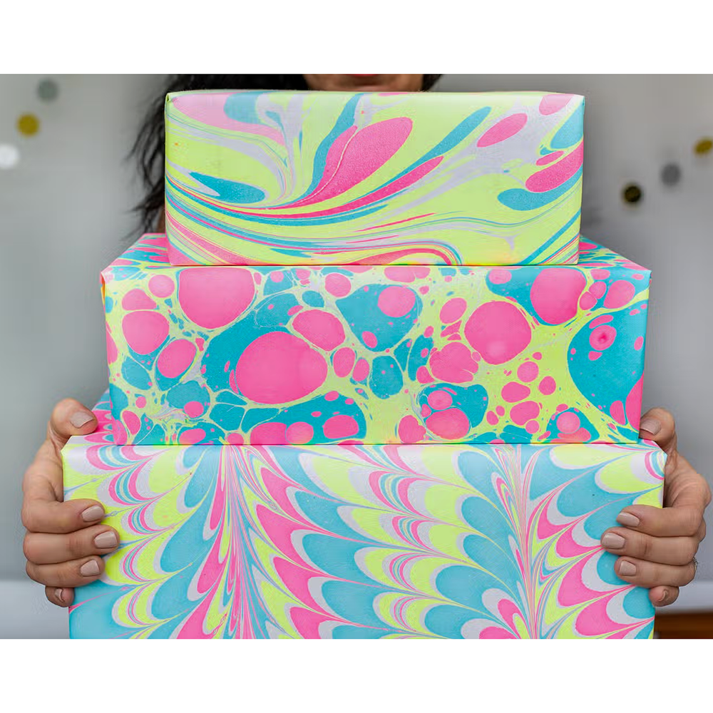 Neon waves and neon pebble papers wrapped packages stacked and held in hands