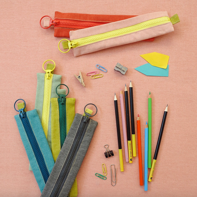 6 Midcentury Style Zipper Pouches shown with pencils on pink background