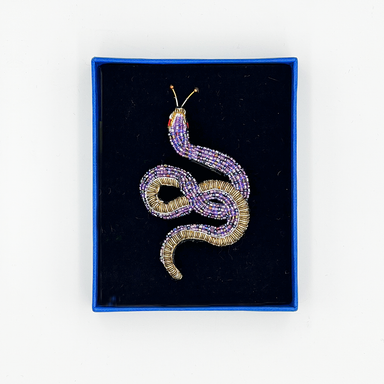 Beaded snake brooch in a blue box with black velvet lining on a white background