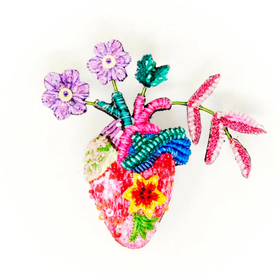 Colorful heart-shaped anatomical heart beaded brooch with floral elements on a white background