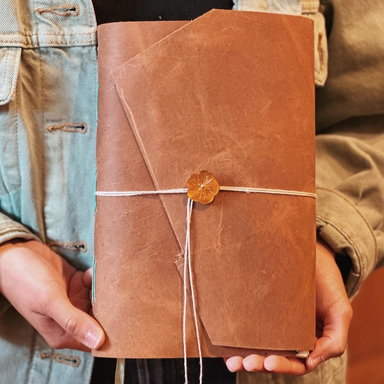 Medieval Leather Journal Class sample with student holding finished book