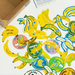 Collection of banana-themed stickers on a white surface with a cardboard box in the background.