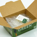 Open cardboard box with packing material and an invoice inside, branded 'Green Market'.