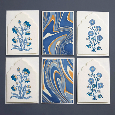 Set of six cards with floral designs and marbled patterns on a dark background