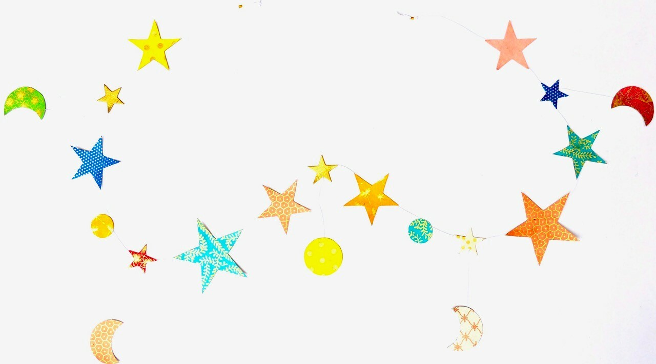 Handmade Lokta Paper Garland with Stars and Moons. Garland features gold printing on a various colors of Lokta paper as a background. 